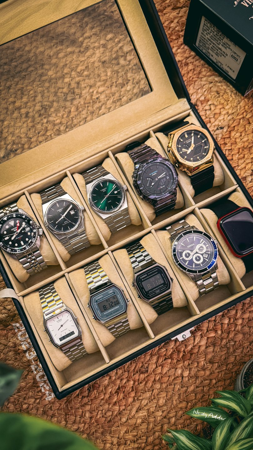 Varios relojes de pulsera dispuestos dentro de una caja de almacenamiento negra.